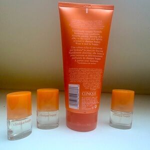 Clinique Happy 6.7 ounce body lotion and 3 mini perfumes .